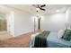Bright main bedroom with modern ceiling fan, tan carpet, and ensuite bathroom entrance at 1874 E Crescent Way, Chandler, AZ 85249