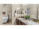Bathroom features a granite countertop with double sinks, decorative mirror, and access to a bedroom at 1903 N Lynch --, Mesa, AZ 85207