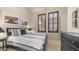 Comfortable bedroom with wooden shutters, a queen bed with neutral bedding, and dresser at 1903 N Lynch --, Mesa, AZ 85207