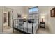 Well-lit bedroom with a wrought iron bed frame, a large window, and stylish decor at 1903 N Lynch --, Mesa, AZ 85207