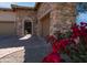 Stone exterior home featuring a gated courtyard entry, multi-car garage, manicured landscaping, and inviting curb appeal at 1903 N Lynch --, Mesa, AZ 85207