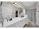 Bright bathroom with double sinks, updated vanity, large mirror, modern fixtures, and wood-look floors at 19815 N 49Th Ave, Glendale, AZ 85308