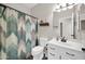 Bathroom featuring a vanity, toilet, patterned shower curtain, and rustic-style wall shelf at 19815 N 49Th Ave, Glendale, AZ 85308