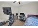 Bedroom setup with exercise bike, workspace, and bed, blending fitness and relaxation at 19815 N 49Th Ave, Glendale, AZ 85308