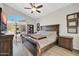 Bedroom features a wooden bed frame, ceiling fan and a large window with a view at 19815 N 49Th Ave, Glendale, AZ 85308