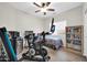 Bedroom equipped with exercise bike, desk setup, storage, and a ceiling fan, with natural light at 19815 N 49Th Ave, Glendale, AZ 85308