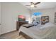 Cozy bedroom with a ceiling fan, a large window providing natural light and wood-look flooring at 19815 N 49Th Ave, Glendale, AZ 85308