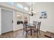Bright dining area features modern chandelier, table with chairs, high ceilings, and backyard view at 19815 N 49Th Ave, Glendale, AZ 85308