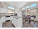 Sun-filled eat-in kitchen features white cabinetry, an island, granite countertops, and wood-look floors at 19815 N 49Th Ave, Glendale, AZ 85308