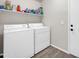 Functional laundry room equipped with a washer, dryer, and shelving for storage at 19815 N 49Th Ave, Glendale, AZ 85308