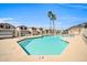 Community pool with crystal clear water and two palm trees set against a bright blue sky at 19815 N 49Th Ave, Glendale, AZ 85308