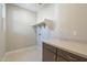 Clean and bright laundry room with upper shelving, modern cabinets and light stone counter at 2121 W Sonoran Desert Dr # 21, Phoenix, AZ 85085