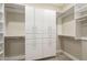 Organized walk-in closet with white built-in shelving, cabinets, and hanging rods at 2121 W Sonoran Desert Dr # 21, Phoenix, AZ 85085