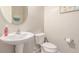 Clean half bathroom featuring a pedestal sink, toilet, and elegant decorative mirror. Neutral wall color at 2167 W Ethan Ct, San Tan Valley, AZ 85144