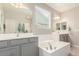Bathroom with soaking tub, dual vanities, and a large window providing natural light at 2167 W Ethan Ct, San Tan Valley, AZ 85144