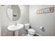 Clean powder room with a pedestal sink, toilet, and coastal-themed decor at 2167 W Ethan Ct, San Tan Valley, AZ 85144