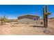 Exterior showing the side and back of the home with arid surroundings and a cactus at 25958 W Muirfield Dr, Morristown, AZ 85342