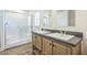 Modern bathroom featuring double sinks, custom cabinets, and glass shower at 25958 W Muirfield Dr, Morristown, AZ 85342