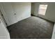 Bedroom with plush gray carpet, window, and neutral walls create a comfortable retreat at 25958 W Muirfield Dr, Morristown, AZ 85342