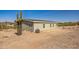 Exterior of home with cactus, showing desert landscape with a blue sky at 25958 W Muirfield Dr, Morristown, AZ 85342