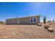 Exterior view of ranch-style home with low-pitched roof surrounded by desert landscape at 25958 W Muirfield Dr, Morristown, AZ 85342