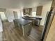 Open kitchen with a large island, stainless steel appliances, and wood-look floors offers modern convenience at 25958 W Muirfield Dr, Morristown, AZ 85342