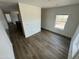 Well-lit living room showcasing wood-look floors and a window providing natural light and views at 25958 W Muirfield Dr, Morristown, AZ 85342