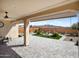 Back patio with pavers under a covered patio overlooking a desert landscaped backyard with a fountain at 27391 W Wahalla Ln, Buckeye, AZ 85396