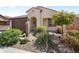 Charming front exterior with desert landscaping and arched entryway, showcasing a well-maintained and inviting facade at 27391 W Wahalla Ln, Buckeye, AZ 85396