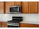 Updated kitchen boasts stainless steel appliances, subway tile backsplash, and light wood cabinetry at 27391 W Wahalla Ln, Buckeye, AZ 85396