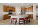 Well-equipped kitchen with granite countertops, stainless steel appliances, and a center island with stool seating at 27391 W Wahalla Ln, Buckeye, AZ 85396