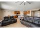 Open-concept living space with tile floors, leather furniture, and kitchen view, perfect for modern living and entertaining at 27391 W Wahalla Ln, Buckeye, AZ 85396