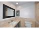 Updated bathroom features stone countertops, dark wood cabinets, framed mirror, and decorative tiled backsplash at 2808 E Lupine Ave, Phoenix, AZ 85028