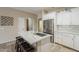 Bright kitchen with white cabinets, stainless steel refrigerator, island with seating, and modern finishes at 29322 N Red Finch Dr, San Tan Valley, AZ 85143