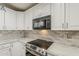 Close-up of a kitchen featuring modern appliances, white cabinetry, and stylish countertops at 29322 N Red Finch Dr, San Tan Valley, AZ 85143