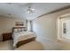 A serene main bedroom with carpet, ceiling fan and en-suite bathroom at 29322 N Red Finch Dr, San Tan Valley, AZ 85143