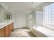 Bright bathroom with double sinks, bathtub, and glass enclosed shower at 2982 E Boston St, Gilbert, AZ 85295