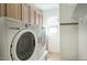 Practical laundry area with tile floors, a side-by-side washer and dryer set, and storage cabinets at 2982 E Boston St, Gilbert, AZ 85295