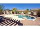 A backyard oasis features a sparkling pool, desert landscaping, and a shaded pergola with a built-in grill at 2982 E Boston St, Gilbert, AZ 85295
