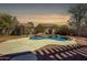 Sparkling pool surrounded by rock features, landscaping, and serene sunset views at 2982 E Boston St, Gilbert, AZ 85295