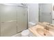 Bathroom with a toilet, framed mirror, sink, and a shower behind sliding frosted glass doors at 3023 W Calavar Rd, Phoenix, AZ 85053