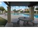 Community pool featuring a covered patio with seating and well-maintained landscaping on a sunny day at 3023 W Calavar Rd, Phoenix, AZ 85053