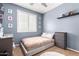 Cozy bedroom with a bed, window with shutters, shelving and natural light at 3343 E Ivanhoe St, Gilbert, AZ 85295