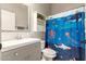 Bright bathroom featuring a decorative mirror, cute shower curtain, and modern vanity with ample storage at 3668 E Cody Ave, Gilbert, AZ 85234