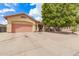 Charming single-story home boasts a low-maintenance gravel front yard and a two-car garage with a pink door at 3668 E Cody Ave, Gilbert, AZ 85234