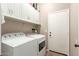 Functional laundry room with modern washer and dryer, plenty of storage cabinets, and easy backyard access at 3668 E Cody Ave, Gilbert, AZ 85234