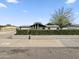 Well-kept home featuring a manicured hedge, desert landscaping, and a large tree providing ample shade at 3802 W Rue De Lamour Ave, Phoenix, AZ 85029