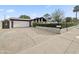 Charming home featuring a well-maintained front yard with a hedge and a spacious driveway leading to a two-car garage at 3802 W Rue De Lamour Ave, Phoenix, AZ 85029
