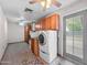 Bright laundry room with built-in cabinets and modern washer and dryer next to door leading to backyard at 3802 W Rue De Lamour Ave, Phoenix, AZ 85029