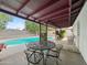 Covered patio with outdoor seating area that overlooks a sparkling in-ground pool and lush landscaping at 3802 W Rue De Lamour Ave, Phoenix, AZ 85029